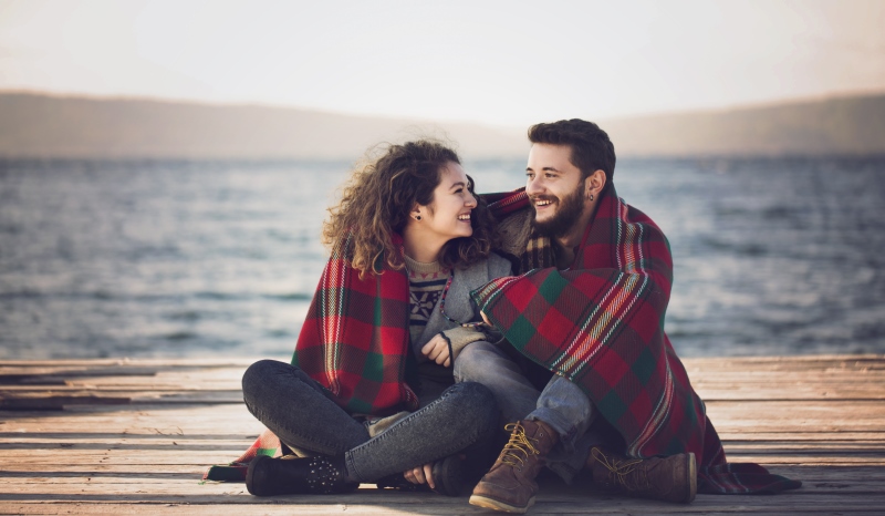 couple huddled under a blanket together_New_Love_Times