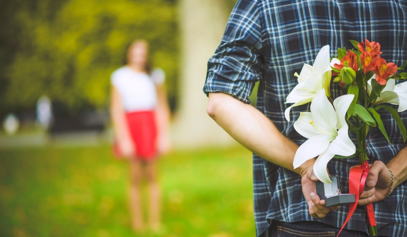 man holding flowers behind his back_New_Love_Times