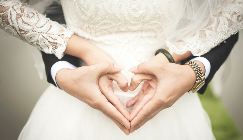 couple forming a heart with their hands