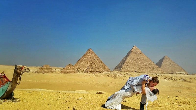 the couple kissing in front of the pyramids of giza