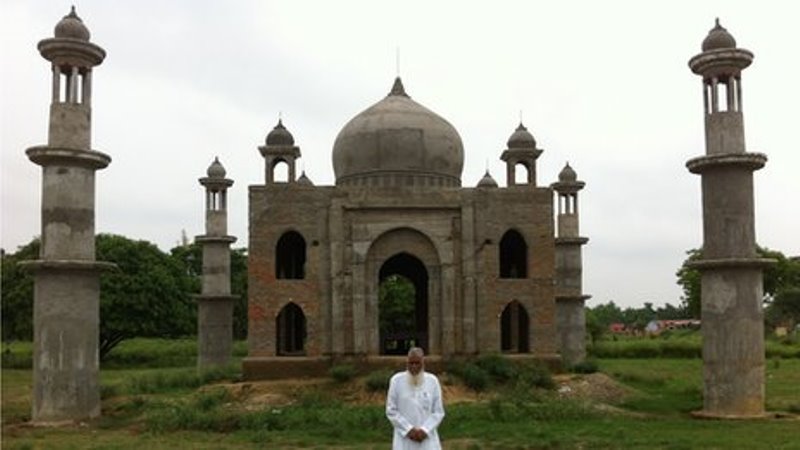 faizul hasan qadri standing in front of the replica of taj mahal that he's building for his late wife