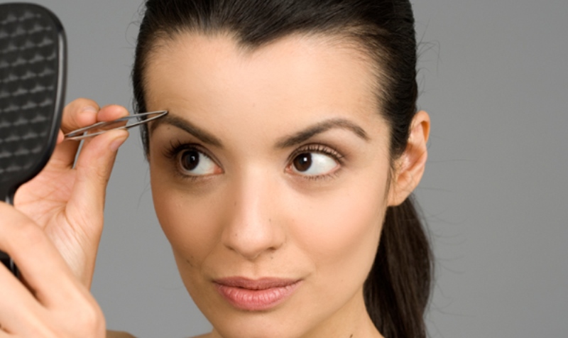 woman plucking eyebrows