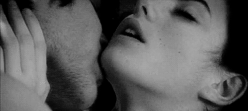 man kissing a woman's neck