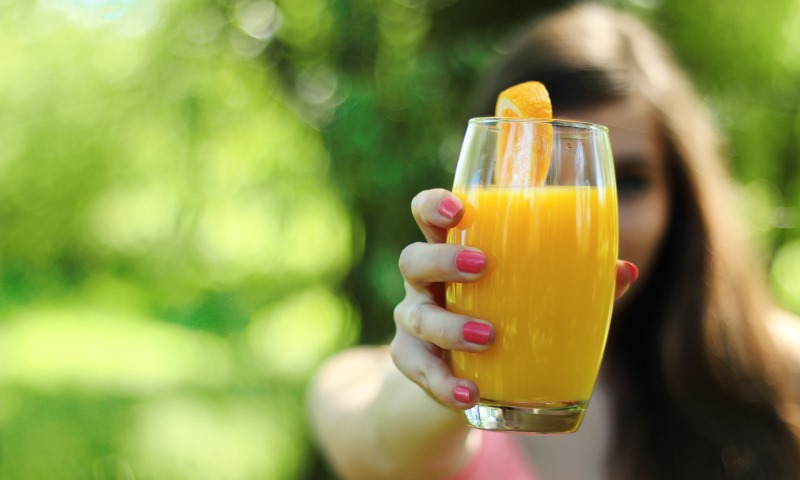 woman holding a glass of juice_New_Love_Times